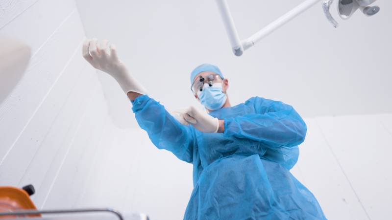 Chirurgien dentiste se prepare pour la pose d'implant dentaire